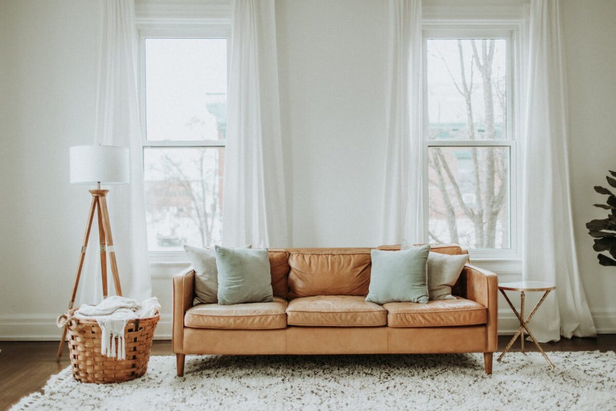 white-and-brown-sofa-chair-near-white-window-curtain